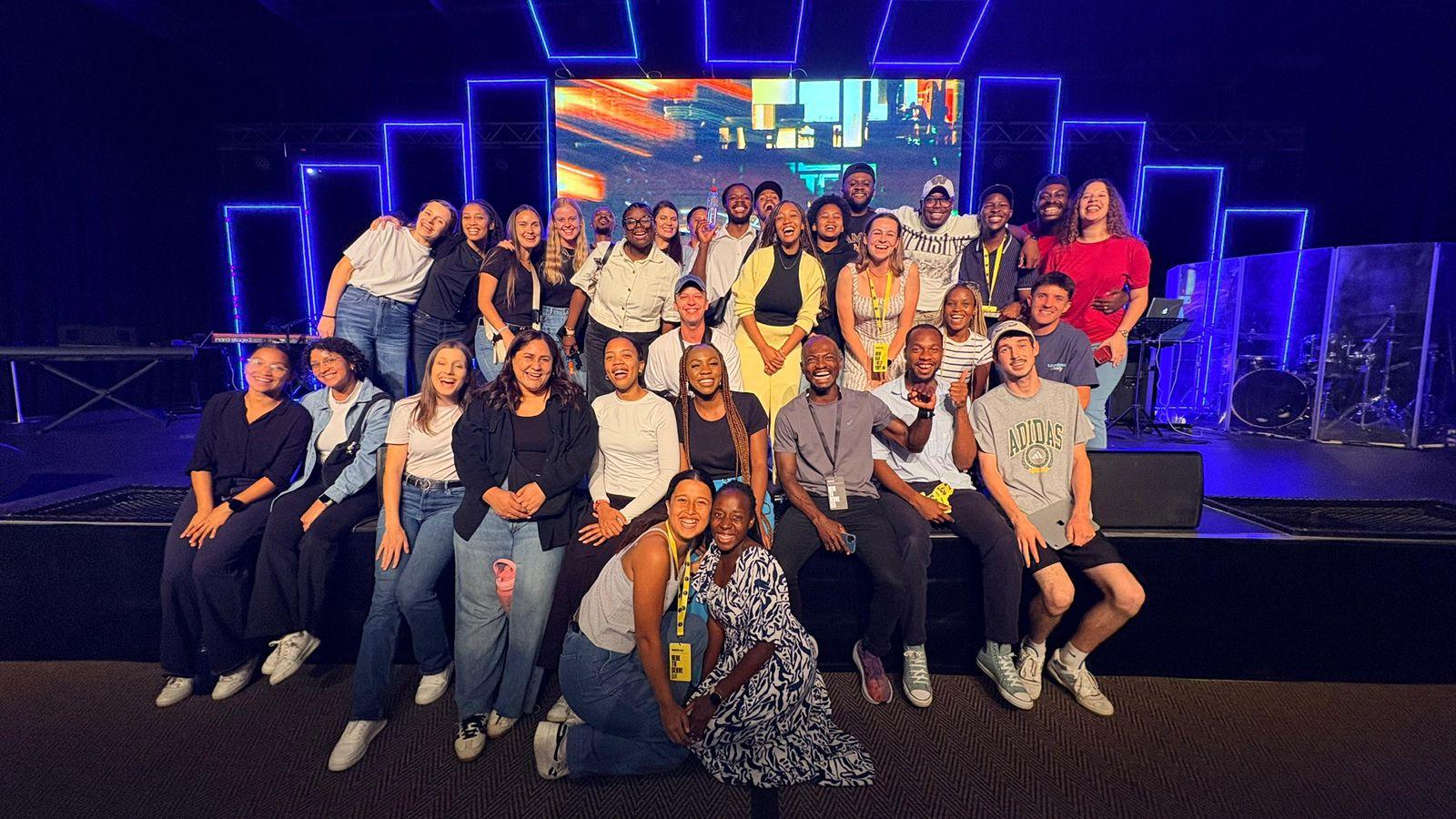 A large group of Helderberg Young Adults smiling together after a gathering
