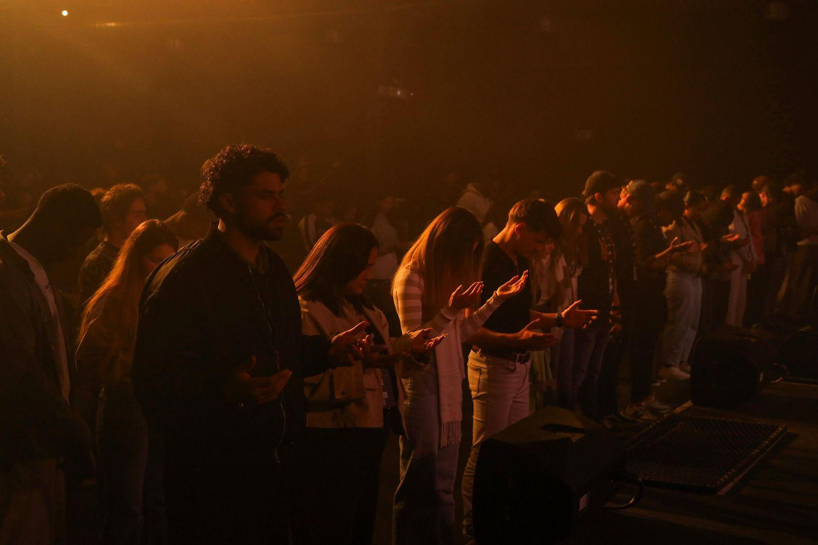 A crowd praying together at First Thursday