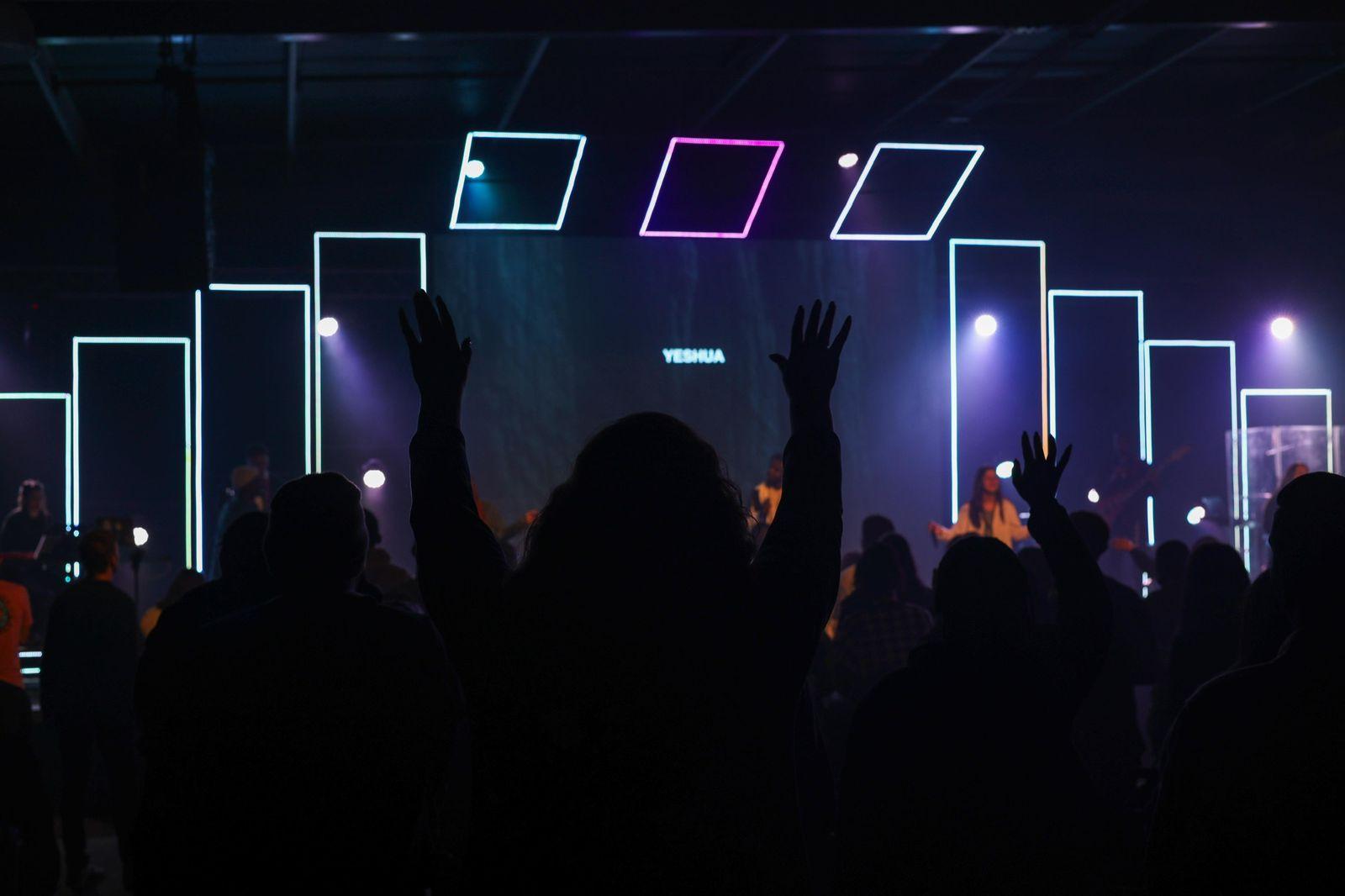 Hands raised in worship at a Helderberg Young Adults gathering